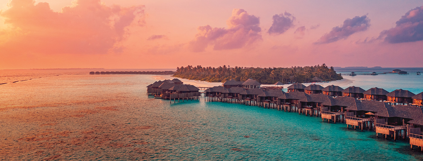 the sea surrounding a few small bungalows
