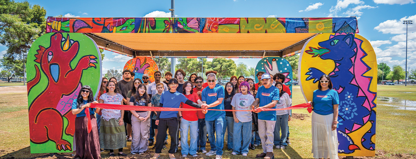 Photo of a group of people cutting a red ribbon